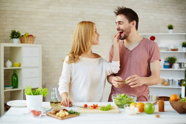 Mujer poniendo tomate en la boca del marido — Foto de Stock