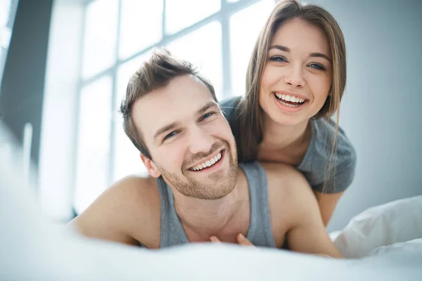 Pareja acostada en la cama por la mañana — Foto de Stock