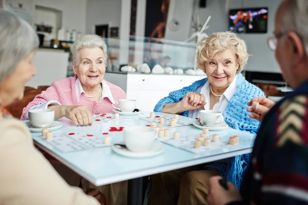 Amici anziani che giocano al lotto nel tempo libero — Foto Stock