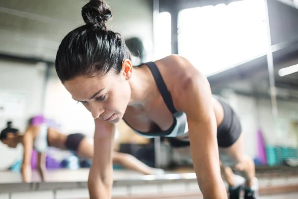 Kvinnan gör armhävningar i gym — Stockfoto