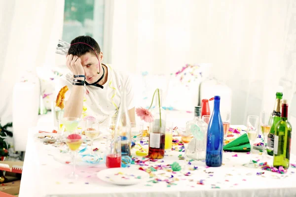 Man sitting at messy table after party — Stock Photo, Image