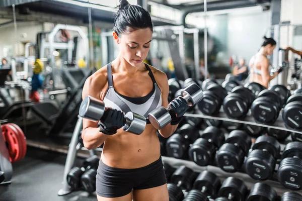 Mujer haciendo ejercicio con pesas metálicas — Foto de Stock