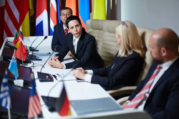 Delegate listening to colleague at summit — Stock Photo, Image