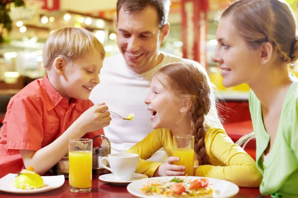 Familia con dos niños sentados en la cafetería — Foto de Stock