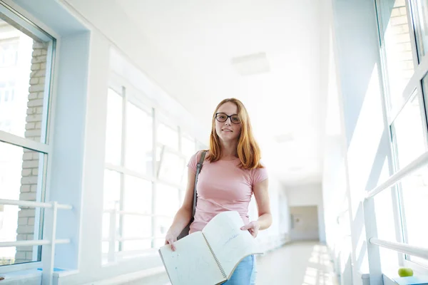 Estudiante con copybook de pie en corredor de la universidad — Foto de Stock