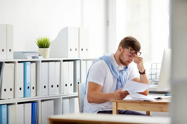 Empresário cansado sentado por local de trabalho — Fotografia de Stock