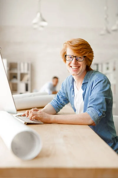 Empresário alegre sentado por computador no escritório — Fotografia de Stock