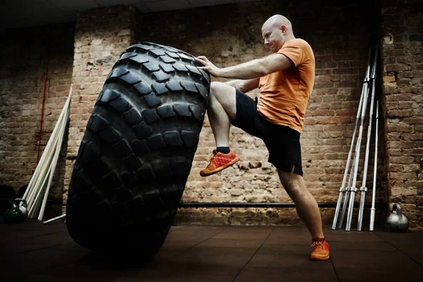 Sportsman flipping tire during workout — Stock Photo, Image