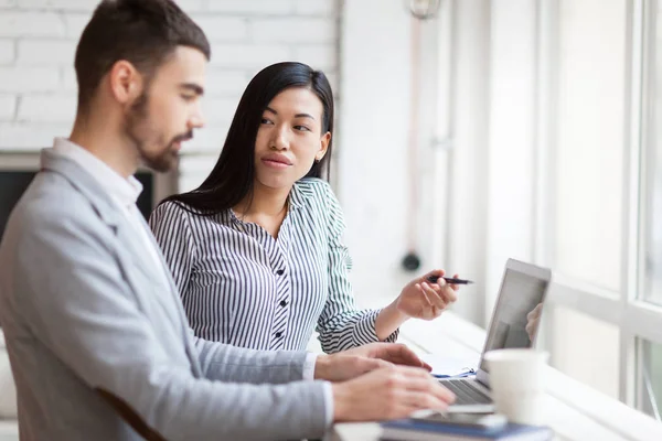 Mujer explicando datos electrónicos a colega — Foto de Stock