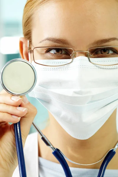 Молодой доктор в маске со стетоскопом — стоковое фото