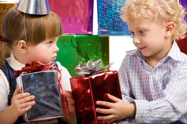 Lächelnder Junge schenkt Mädchen ein Geschenk — Stockfoto