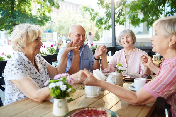 Senior vänner håller händerna på te tid — Stockfoto