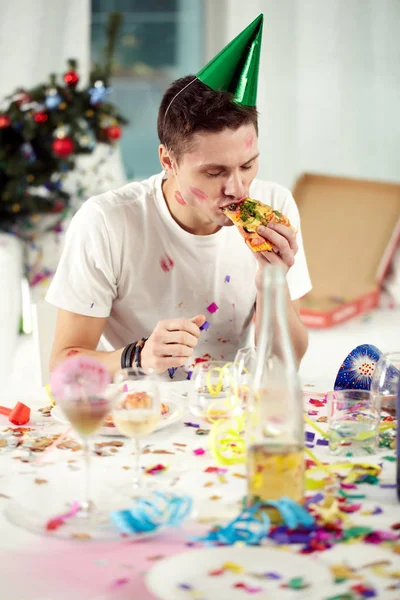 Man eating pizza after roaring night — Stock Photo, Image