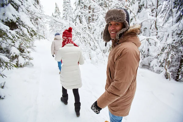 Unga människor som vandrar i vinter skog — Stockfoto