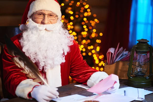 Papai Noel sentado à mesa — Fotografia de Stock