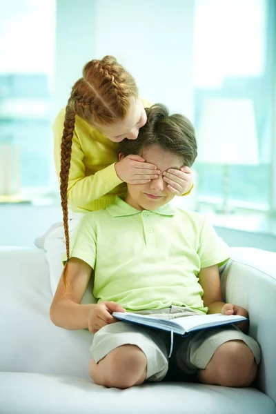 Menina fechando os olhos de seu irmão — Fotografia de Stock