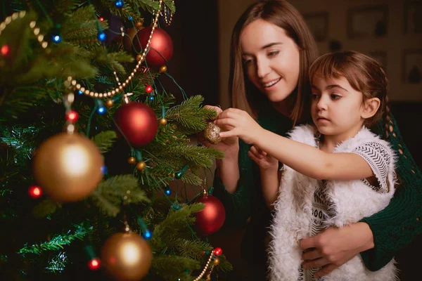 Kleines Mädchen und ihre Mutter schmücken Weihnachtsbaum — Stockfoto