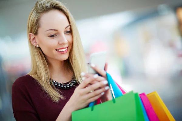 Shopper čtení promo sms na mobilním telefonu — Stock fotografie