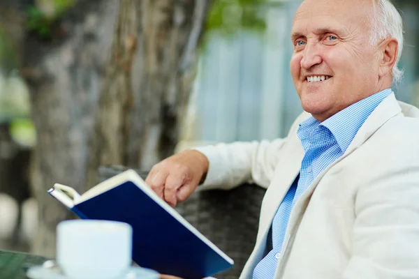 Gelukkig senior man met open boek — Stockfoto