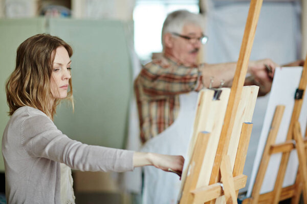 woman standing in front of easel