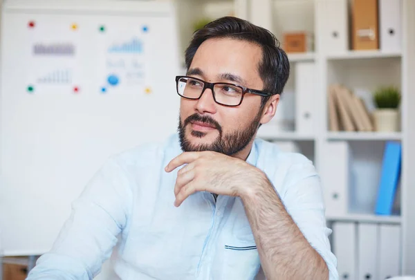 Jeune homme d'affaires en lunettes assis au bureau — Photo