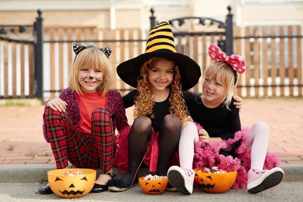 Halloween chicas con golosinas mirando a la cámara — Foto de Stock