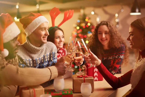 Amigos brindando con champán en la noche de Navidad —  Fotos de Stock