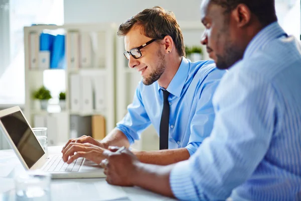 Managers looking together at laptop — Stock Photo, Image