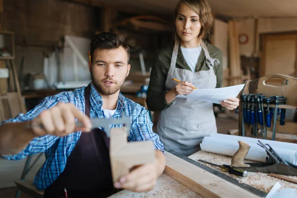 Male carpenter measuring wooden detail — Stock Photo, Image