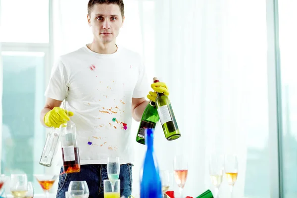 Hombre guardando botellas de vino vacías — Foto de Stock