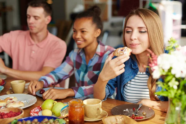 Girl with her friends by table — Stock Photo, Image