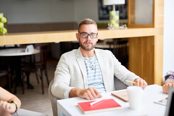 Geschäftsmann blickt am Arbeitsplatz auf Kamera — Stockfoto