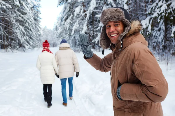 Man in winter forest zwaaien naar de camera — Stockfoto