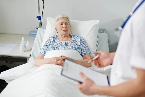 Пожилая пациентка слушает рецепты врача — стоковое фото
