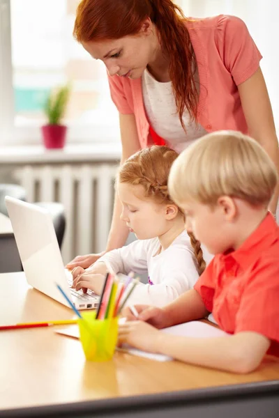 Lehrer überprüft, wie Schüler Hausaufgaben machen — Stockfoto