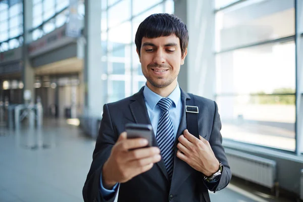 Homme d'affaires lisant des SMS dans son smartphone — Photo