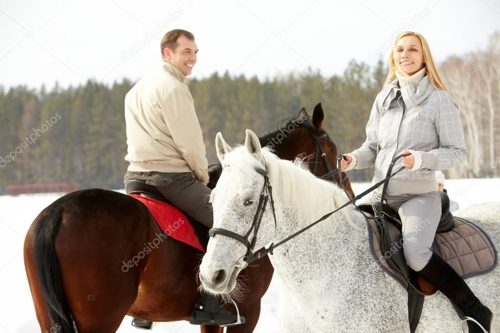 couple horseback riding in winter 