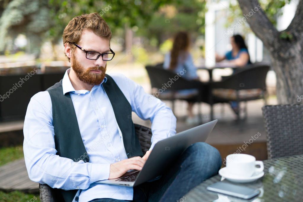 Pensive man typing on laptop 