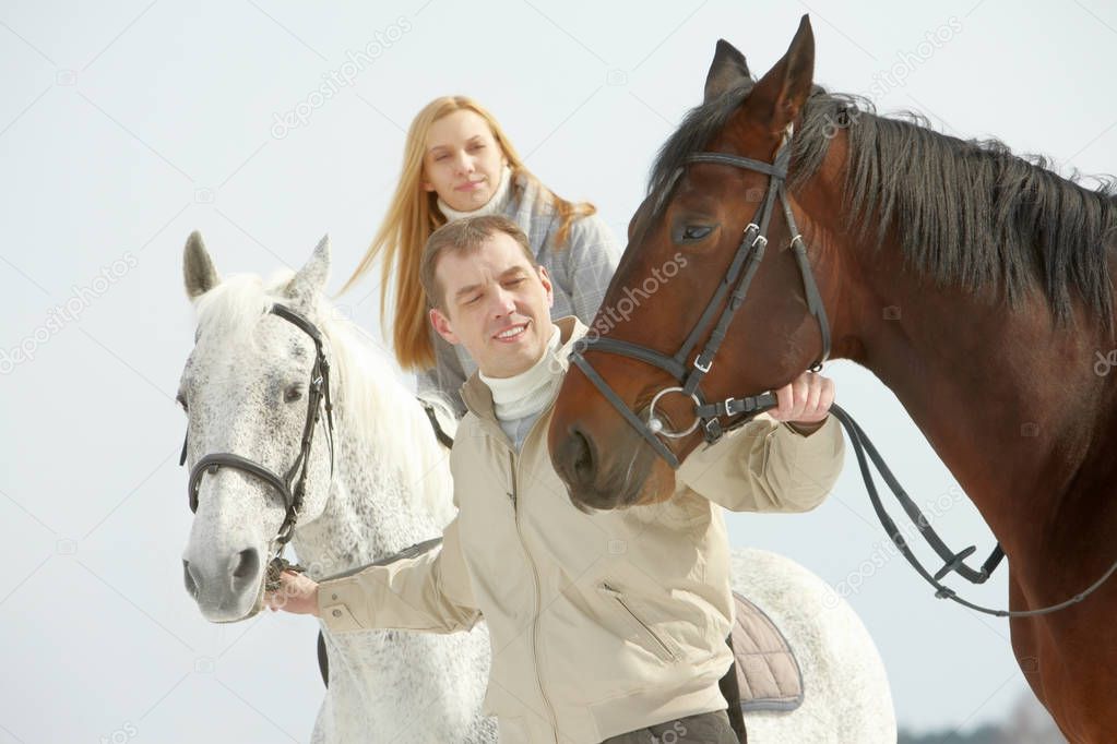 man leading two horses