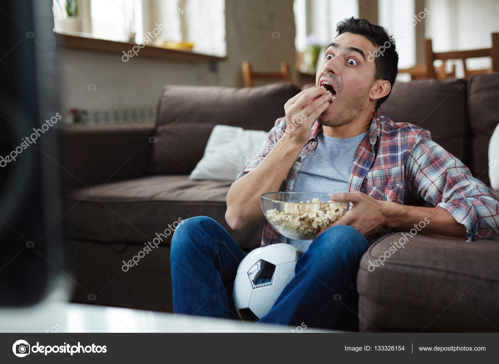 Guys sitting in front of tv Stock Photo by ©pressmaster 133326154