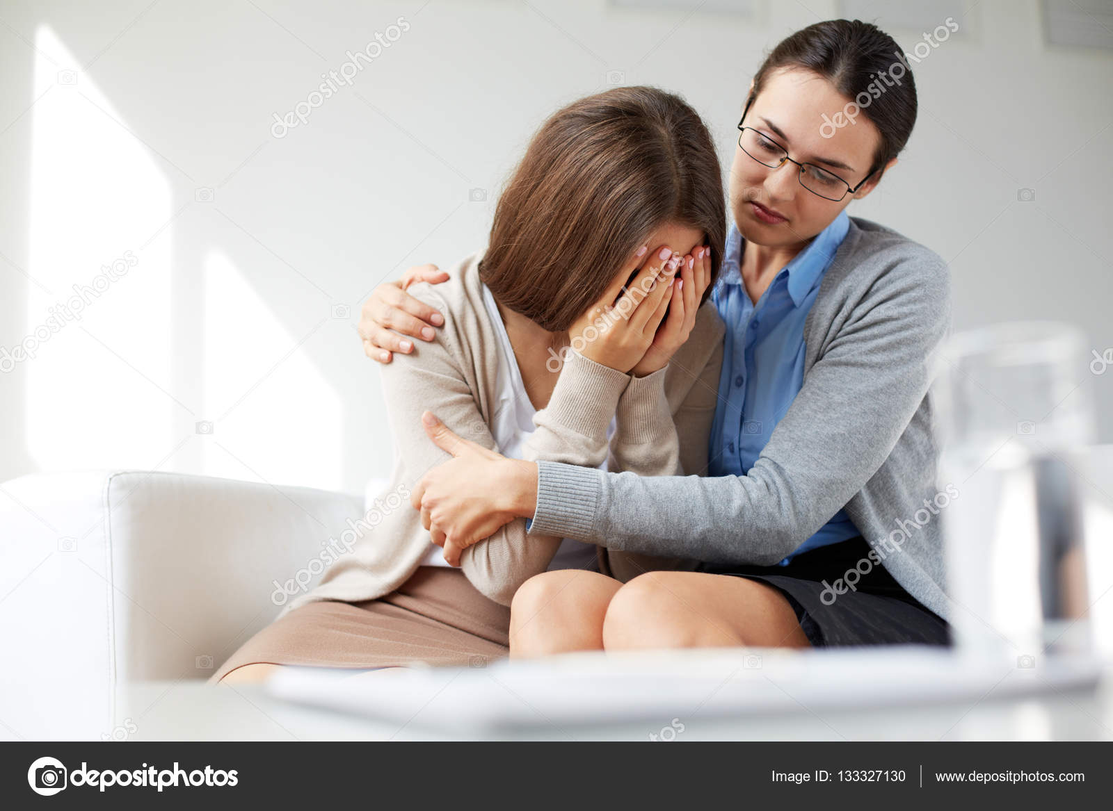 而心理学家拥抱着她哭的女孩——图库图片© pressmaster #133327130