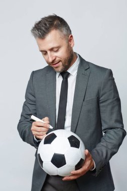 soccer trainer signing ball for fans