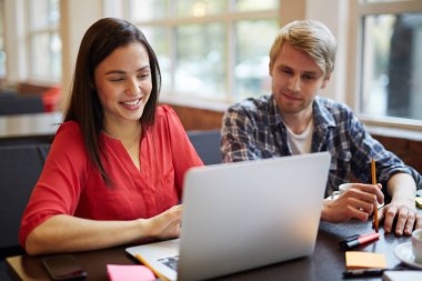 Genç adam ve kadın dizüstü bilgisayar ile