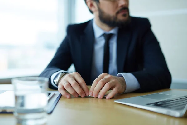 Affärsman mellan laptop och dokument — Stockfoto