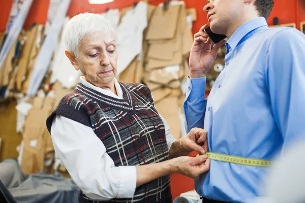 Tailor measuring waist of businessman — Stock Photo, Image