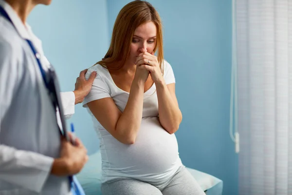 Zwangere vrouw huilen met dokter in de buurt van door — Stockfoto