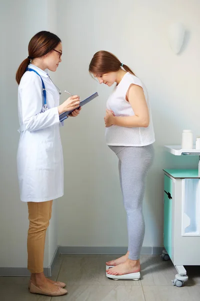 Verloskundige consulting jonge zwangere vrouw — Stockfoto