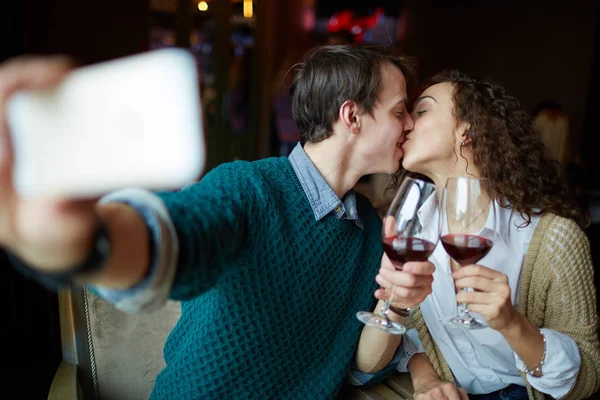 Mladý muž líbání svou ženu v restauraci — Stock fotografie