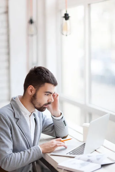 Joven comerciante mirando portátil — Foto de Stock