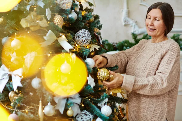 Seniorin schmückt Weihnachtsbaum — Stockfoto